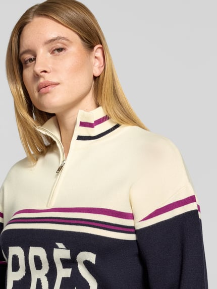 Frauenmodel trägt Troyer mit Après-Schriftzug von JAKE*S WOMAN CASUAL in mehrfarbiger Strickoptik, gestreift, Nahaufnahme Oberkörper.