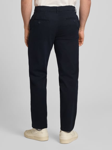Männermodel trägt Straight Fit Chino mit Eingrifftaschen Modell 'Vance' von Jack & Jones in Dunkelblau, Baumwoll-Mix, Ganzkörperansicht Rückansicht. Bundweite 43 cm, Innenbeinlänge 67 cm, Gesäßtaschen, Knopf- und Reißverschluss.
