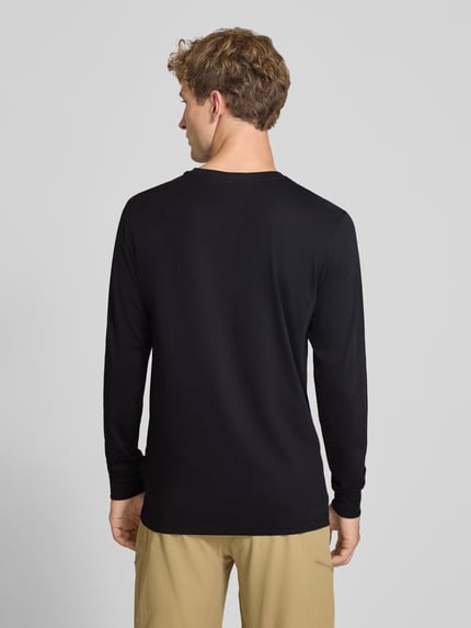 Männermodel trägt Langarmshirt aus Baumwoll-Mix Modell 'EVOLUTION' von The North Face, schwarze Farbe, lockere Passform, Ganzkörperansicht Rückansicht.