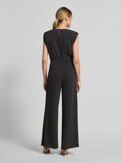 Frauenmodel trägt Jumpsuit mit V-Ausschnitt und Bindegürtel von Comma, schwarz, Material-Mix mit Stretch-Anteil, Regular-Fit, Ganzkörperansicht Rückansicht.