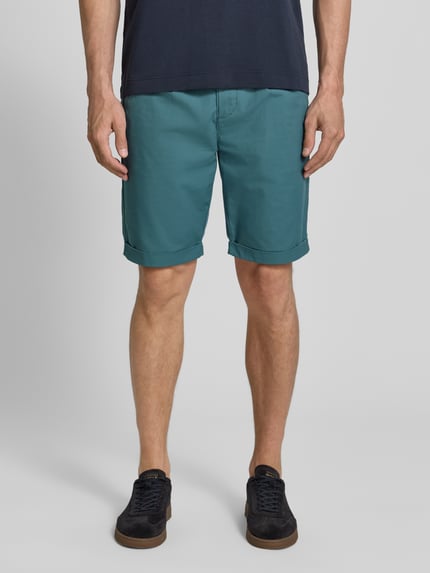 Männermodel trägt Chino-Shorts mit Gesäßleistentaschen von Lerros in Türkis, Baumwoll-Mix mit Stretch-Anteil, Straight Fit, Ganzkörperansicht von vorne. Bundweite 42 cm, Innenbeinlänge 24 cm, mit Elastischer Bund, Knopf-Reißverschluss, Französische Eingrifftaschen.