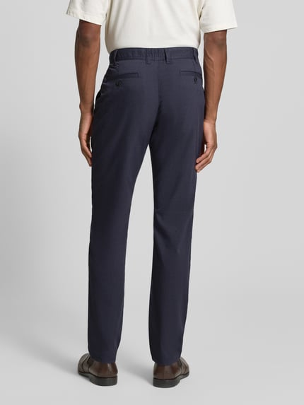 Mannelijk model draagt Slim Fit Stoffhose met Viskose-Anteil van MCNEAL in donkerblauw, rechte pijpen, achteraanzicht hele lichaam. Elastische mix, steekzakken, achterzakken, knoop- en ritssluiting, maat 50: bandwijdte 45 cm, binnenbeenlengte 82 cm.