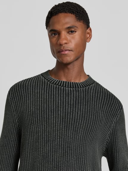 Męski model nosi sweter z dzianiny z prążkowanymi wykończeniami Strickpullover mit gerippten Abschlüssen von Antony Morato, bawełna, krój regular fit, Długość tyłu w rozmiarze M: 70 cm, Długość rękawów w rozmiarze M: 69 cm, ujęcie z przodu, zbliżenie na górną część ciała.