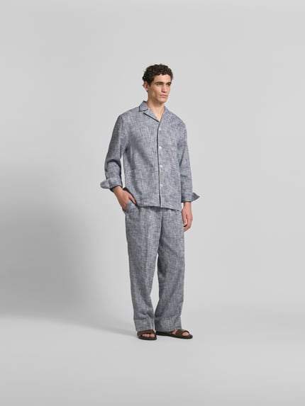 Männermodel trägt Wide Fit Stoffhose mit Bügelfalten von Officine Générale in Reine Baumwolle, elastischer Bund mit Tunnelzug, Ganzkörperansicht von vorne.