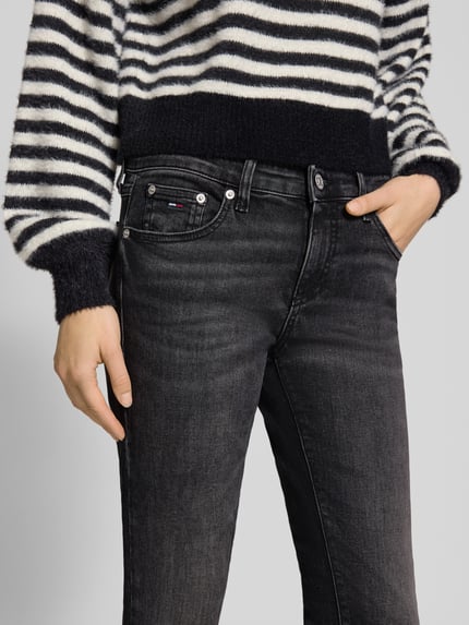 Vrouwenmodel draagt Skinny Fit Jeans uit katoenmix model 'SOPHIE' van Tommy Jeans, melange, 5-pocket denim, low waist, label details. Nahaufnahme Oberkörper.