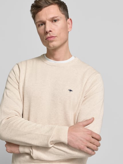 Männermodel trägt Strickpullover mit gerippten Abschlüssen von Fynch-Hatton in Beige, reine Baumwolle, Regular-Fit, Rundhalsausschnitt, Label-Stitching, Nahaufnahme Oberkörper.