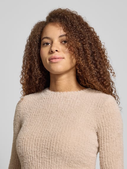 Frauenmodel trägt Slim Fit Strickpullover Modell 'VIOLA' von Only, Optik: Unifarben, Rundhals, Langarm, Strick, Nahaufnahme Oberkörper.