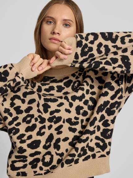Frauenmodel trägt Relaxed Fit Pullover aus Viskose-Mix Modell 'Charlott' von NOISY MAY®, beiges Animal-Print, gerippte Abschlüsse, Langarm, Nahaufnahme Oberkörper.