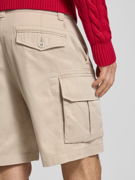 Męskimodel nosi Relaxed Fit Cargoshorts aus reiner Baumwolle von Polo Ralph Lauren, jednokolorowy efekt, wyhaftowane logo, szlufki na pasek, zapięcie na guzik i zamek błyskawiczny, wpuszczane kieszenie, kieszenie z tyłu na guzik, kieszenie cargo, tkana faktura, bawełna. Ganzkörperansicht Rückansicht.