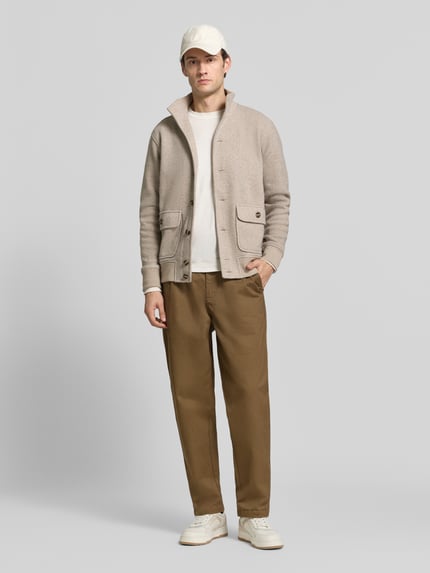 Männermodel trägt Strickjacke aus Wolle mit Stehkragen von RAGMAN in Beige, Strukturstrick, Pattentaschen, Ganzkörperansicht von vorne.