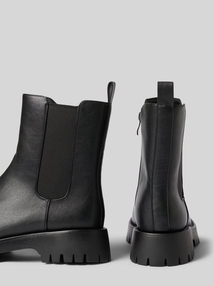 Produktfoto, Boots mit elastischen Einsätzen und profilierter Sohle von BIANCO aus schwarzem Leder, strukturierte Oberfläche, abgerundete Spitze, sichtbarer Reißverschluss, Damenmodell, Absatzhöhe 4 cm, Schafthöhe 17 cm, Schaftweite 12 cm.