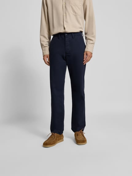 Männermodel trägt Chino mit Gesäßtaschen von Officine Générale in Dunkelblau, Reine Baumwolle, Gerader-Schnitt, Ganzkörperansicht von vorne.