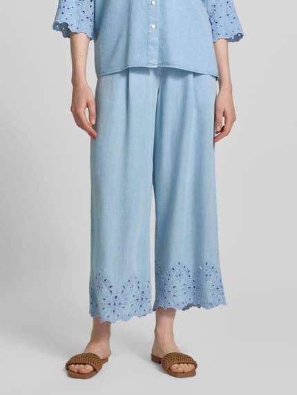 Frauenmodel trägt Hose mit Lochstickerei und französischen Eingrifftaschen von Smith and Soul in Hellblau aus Lyocell, Wide-Leg-Fit, elastischer Bund mit Knopf-Reißverschluss, feine Textur, Ganzkörperansicht von vorne.