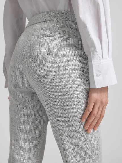 Frauenmodel trägt Regular Fit Anzughose mit Baumwoll-Anteil Modell 'TIMASA1' von BOSS mit Fischgrätmuster, Detailaufnahme Rückansicht.