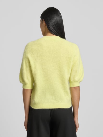 Kobiece modelka nosi Strickpullover aus Wolle mit 1/2-Arm od Herzensangelegenheit, żółty, regular fit, widok całej sylwetki z tyłu.