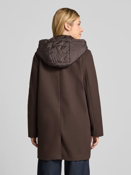 Frauenmodel trägt Mantel mit gesteppter Kapuze Modell 'VMGRACE' von VERO MODA in dunkelbraun, Struktur, Longline, Ganzkörperansicht Rückansicht.