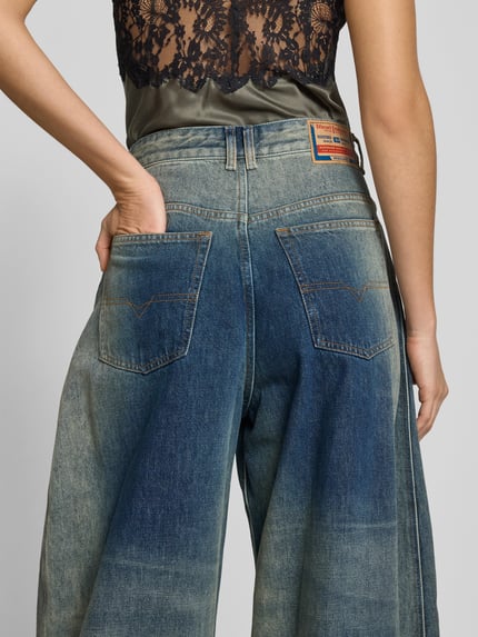 Kobieta nosi Loose Fit Jeans aus Baumwoll-Mix od Diesel, używany wygląd, 5 kieszenie, jeans niebieski, szerokość w rozmiarze 27: 36 cm, długość nogawki 81 cm, zdjęcie całej sylwetki z tyłu.