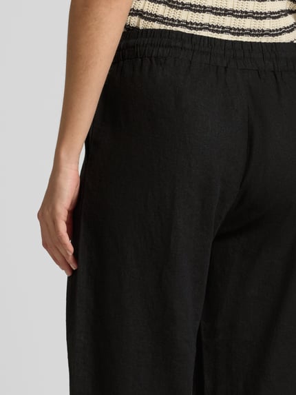 Frauenmodel trägt Wide-Leg-Pants mit elastischem Bund Modell 'Lava' von FREE/QUENT, schwarzer Leinen-Mix mit Viskose-Mix, Detailaufnahme Hüfte.
