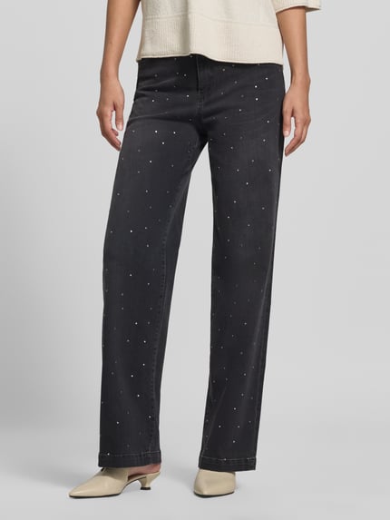 Frauenmodel trägt Straight Fit Jeans aus Baumwoll-Mix mit Allover-Strasssteinbesatz von Marc Cain in Schwarz mit 5-Pocket-Design, Nahaufnahme Unterkörper. Elastischer Baumwoll-Mix, Bundweite 39 cm, Innenbeinlänge 79 cm, Knopf- und Reißverschluss.