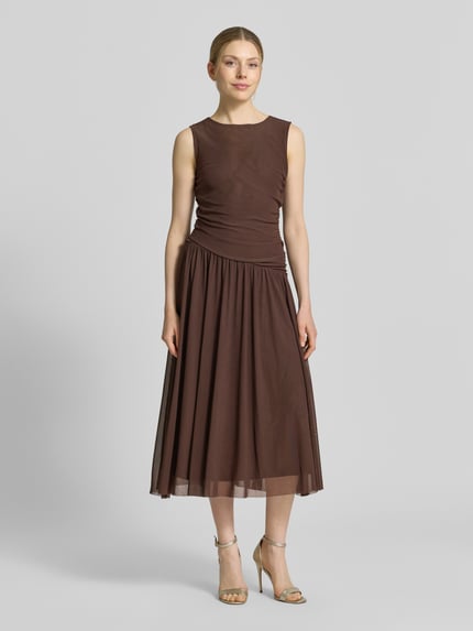 Frauenmodel trägt Midikleid aus Mesh in asymmetrischem Look von Christian Berg Woman Selection, braun, Gerader-Schnitt, Rundhalsausschnitt, feine Mesh-Struktur, Rückenlänge 50 cm, Brustweite 39 cm, Ganzkörperansicht von vorne.