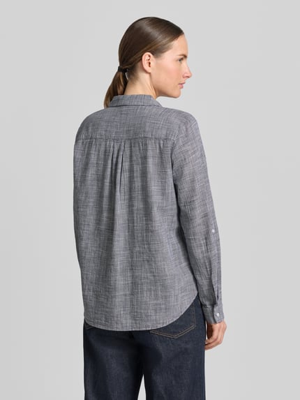 Frauenmodel trägt Regular Fit Hemdbluse aus reiner Baumwolle von Tom Tailor, Optik: Allover-Muster mit Hahnentritt, Ganzkörperansicht Rückansicht.