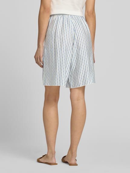 Frauenmodel trägt Shorts aus Lyocell-Mix mit elastischem Bund von American Vintage, weiß-blau gestreift, lockerer Schnitt, Ganzkörperansicht Rückansicht.