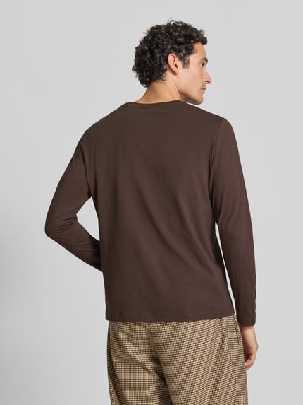 Männermodel trägt Langarmshirt mit Rundhalsausschnitt von S.OLIVER CASUAL in Braun, unifarben, lange Ärmel, Ganzkörperansicht Rückansicht.