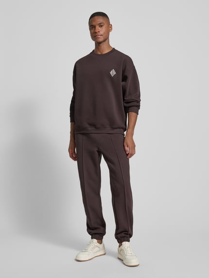 Männermodel trägt Loose Fit Sweatshirt aus Baumwoll-Mix von Lacoste in Optik: Unifarben, mit Logo-Stitching, Ganzkörperansicht von vorne.