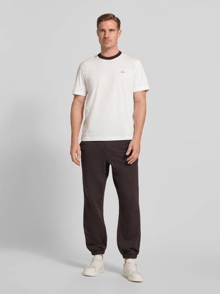 Männermodel trägt Regular Fit T-Shirt aus reiner Baumwolle von Lacoste, Optik: Unifarben, Logo-Detail, Rundhals, Kurzarm, Jersey, Ganzkörperansicht von vorne.