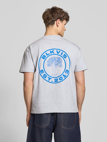 Männermodel trägt T-Shirt mit Logo und Rundhalsausschnitt von BLKVIS in Hellgrau mit blauem Druck, reine Baumwolle, Regular Fit, Ganzkörperansicht Rückansicht.