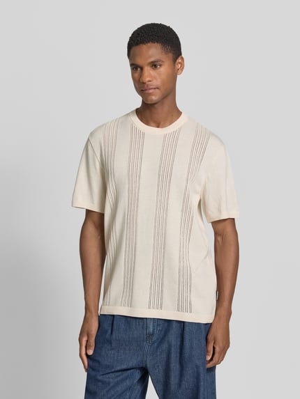 Männermodel trägt Relaxed Fit T-Shirt aus reiner Baumwolle von Armedangels in Optik: Unifarben, Passform: Relaxed-Fit, Label-Patch, Rundhals-Ausschnitt, Ärmelform: Kurzarm, Rumpfabschluss: Gerippt, Materialverarbeitung: Feinstrick, Material: Reine Baumwolle, helle Farben, Strukturstreifen, Ganzkörperansicht von vorne.