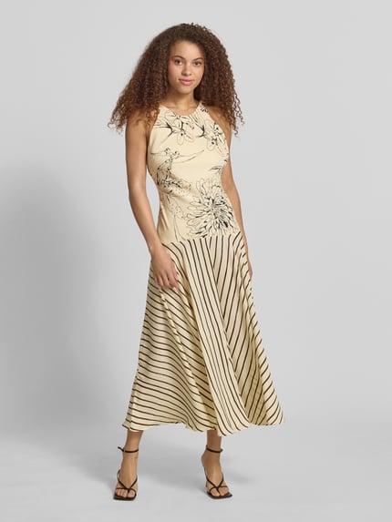Frauenmodel trägt Maxikleid im Allover-Look Modell 'MILLE' von Topshop in Beige mit schwarzen Streifen und floralen Details, taillierter Schnitt, Ganzkörperansicht von vorne. Rückenlänge bei Größe 36: 134 cm, Brustweite: 38 cm, Träger im Perlen-Look.