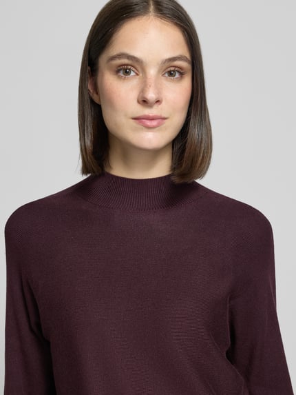 Frauenmodel trägt Regular Fit Strickpullover aus Viskose-Mix mit Stehkragen von COMMA, Ripp-Struktur, weinrote Farbe, Nahaufnahme Oberkörper.