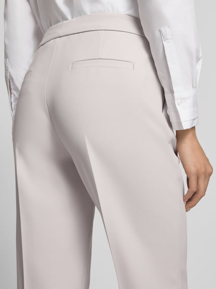Frauenmodel trägt Straight Fit Hose mit Viskose-Anteil von windsor. in hellem Beige, glatte Textur, Detailaufnahme Rückansicht, elastischer Material-Mix.