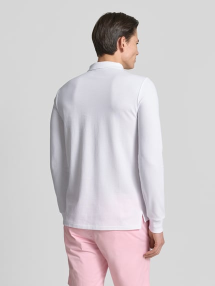 Männermodel trägt Regular Fit Poloshirt aus reiner Baumwolle von Polo Ralph Lauren, weiß, Langarm, Piqué-Textur, Ganzkörperansicht Rückansicht.
