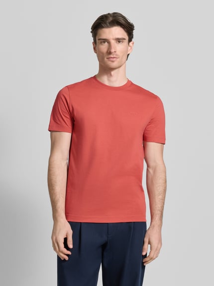 Männermodel trägt Regular Fit T-Shirt aus reiner Baumwolle Modell 'Thompson 01' von BOSS in Unifarbe, Jersey-Textur, Rundhals, Ganzkörperansicht von vorne.