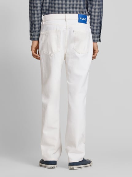 Männermodel trägt Regular Fit Jeans aus reiner Baumwolle Modell 'Jonah' von HUGO in weißer Denim-Optik mit Label-Patch, Ganzkörperansicht Rückansicht.