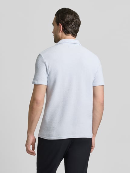Männermodel trägt Regular Fit Poloshirt aus Baumwoll-Mix von MCNEAL in Hellblau, Waffle-Piqueé, Kurzarm, Rückansicht Ganzkörperansicht.