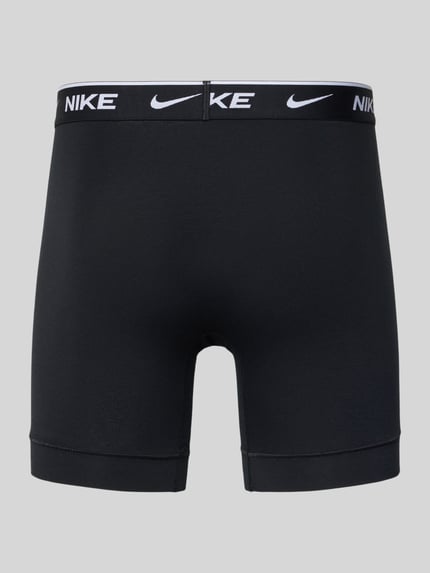 Produktfoto, zwarte Trunks met logo-schriftzug Modell 'E-DAY' van Nike, aansluitende fit, elastische tailleband, labelprint, grijze achtergrond