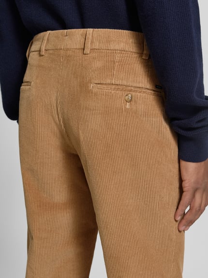 Männermodel trägt Regular Fit Cordhose aus Baumwollmix von Hiltl in Beige mit feiner Cordstruktur, Gesäßtaschen, Nahaufnahme Rückansicht.