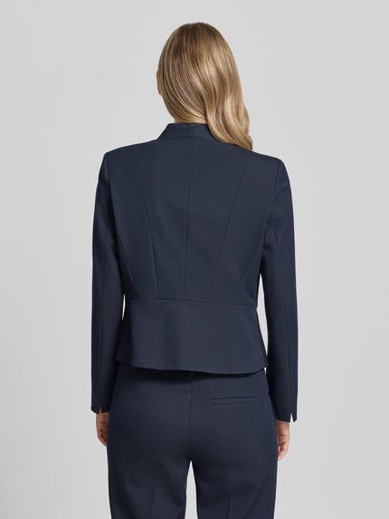 Kobiece modelka ma na sobie Slim Fit Blazer mit Hakenverschluss od Christian Berg Woman Selection, granatowa mieszanka materiałów z dodatkiem wiskozy, dekolt w serek, długość tyłu w rozmiarze 36: 53 cm, szerokość w rozmiarze 36: 46 cm, długość rękawów w rozmiarze 36: 60 cm, całkowity widok z tyłu.
