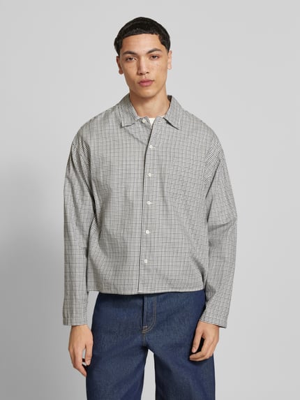 Männermodel trägt Regular Fit Freizeithemd aus Baumwolle Modell 'AUSTIN' von Jack & Jones mit feinem Karomuster, Kentkragen, Knopfleiste, Brusttasche, Farbton Grau-Weiß, weiche Textur, Ganzkörperansicht von vorne. Rückenlänge 60 cm, Schulterbreite 45 cm, Ärmellänge 57 cm.