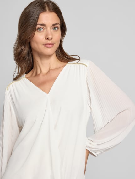 Frauenmodel trägt Bluse mit V-Ausschnitt Modell 'Be44rtaa' von ZABAIONE in Weiß, fließender Stoff, dezente Struktur, Nahaufnahme Oberkörper. Rückenlänge 60 cm, Ärmellänge 58 cm, gerader Schnitt, elastische Abschlüsse.