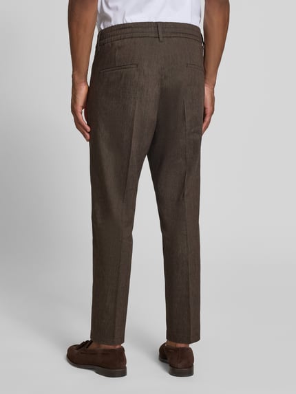 Männermodel trägt Hose mit Bügelfalte und elastischem Bund Modell 'CHASY' von Drykorn, Leinen-Mix, Slim-Fit, Ganzkörperansicht Rückansicht, Herren.