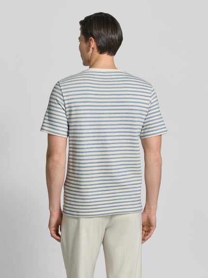 Männermodel trägt Regular Fit T-Shirt aus Baumwoll-Mix Modell 'KEVIN' von SELECTED HOMME in Optik: Allover-Muster, gestreift, Feinstrick, Ganzkörperansicht Rückansicht.
