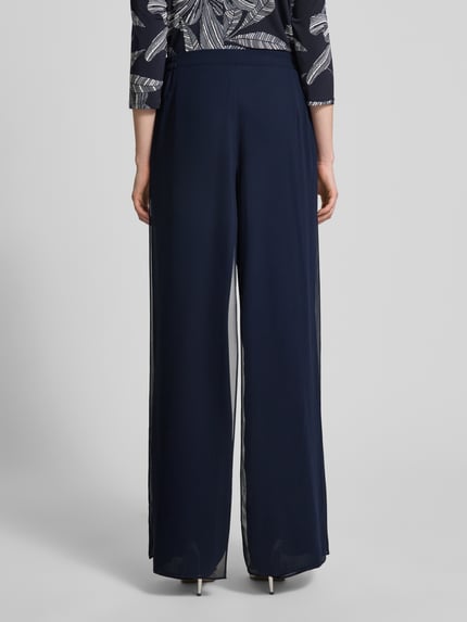 Vrouwenmodel draagt Wide Fit Stoffhose im semitransparentem Design van Vera Mont, donkerblauw, semi-transparant, wikkellook, naadritssluiting, bandwijdte maat 36: 29 cm, binnenbeenlengte maat 36: 86 cm, ganzekijk op de rug.