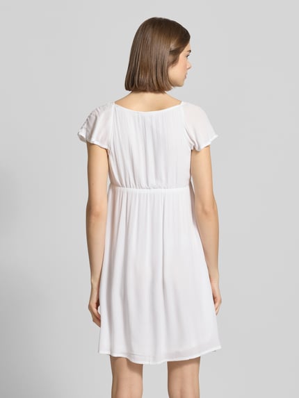 Frauenmodel trägt Babydoll Kleid aus Reine Viskose mit Karree-Ausschnitt und Schleife von REVIEW, Gerader-Schnitt, Minikleid, Rückansicht Ganzkörperansicht.