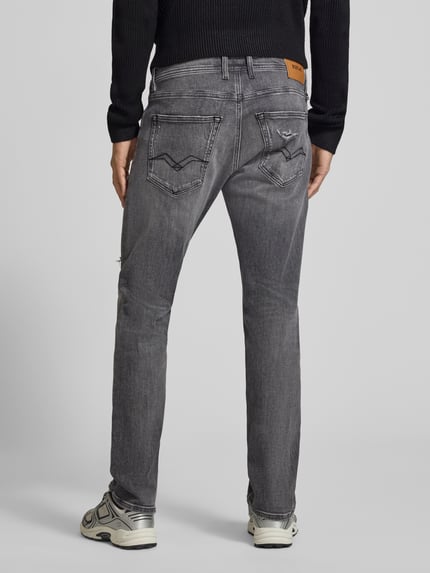 Männermodel trägt Straight Fit Jeans im Used-Look Modell 'Grover' von Replay, grauer Baumwoll-Mix, 5-Pocket-Design, Ganzkörperansicht Rückansicht.