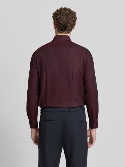 Männermodel trägt Regular Fit Businesshemd mit Kentkragen von OLYMP, unifarbenes Design mit feinem Webstruktur, Ganzkörperansicht Rückansicht.