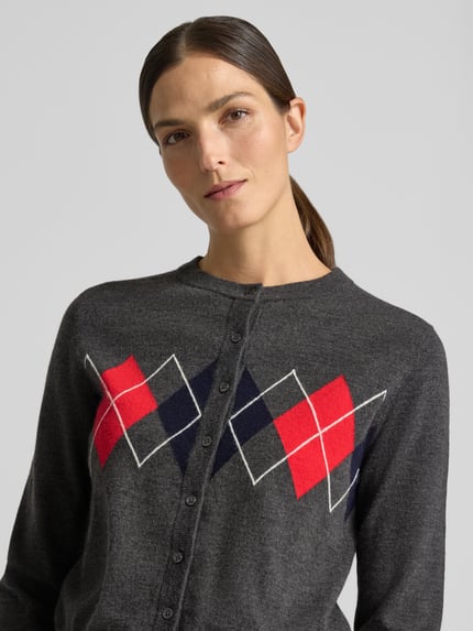 Frauenmodel trägt Strickjacke mit Rundhalsausschnitt Modell 'BIMBU' von MANGO, grau mit rot-blauen Karomustern, Nahaufnahme Oberkörper, Material-Mix mit Woll-Anteil, Regular Fit, Knopfleiste.